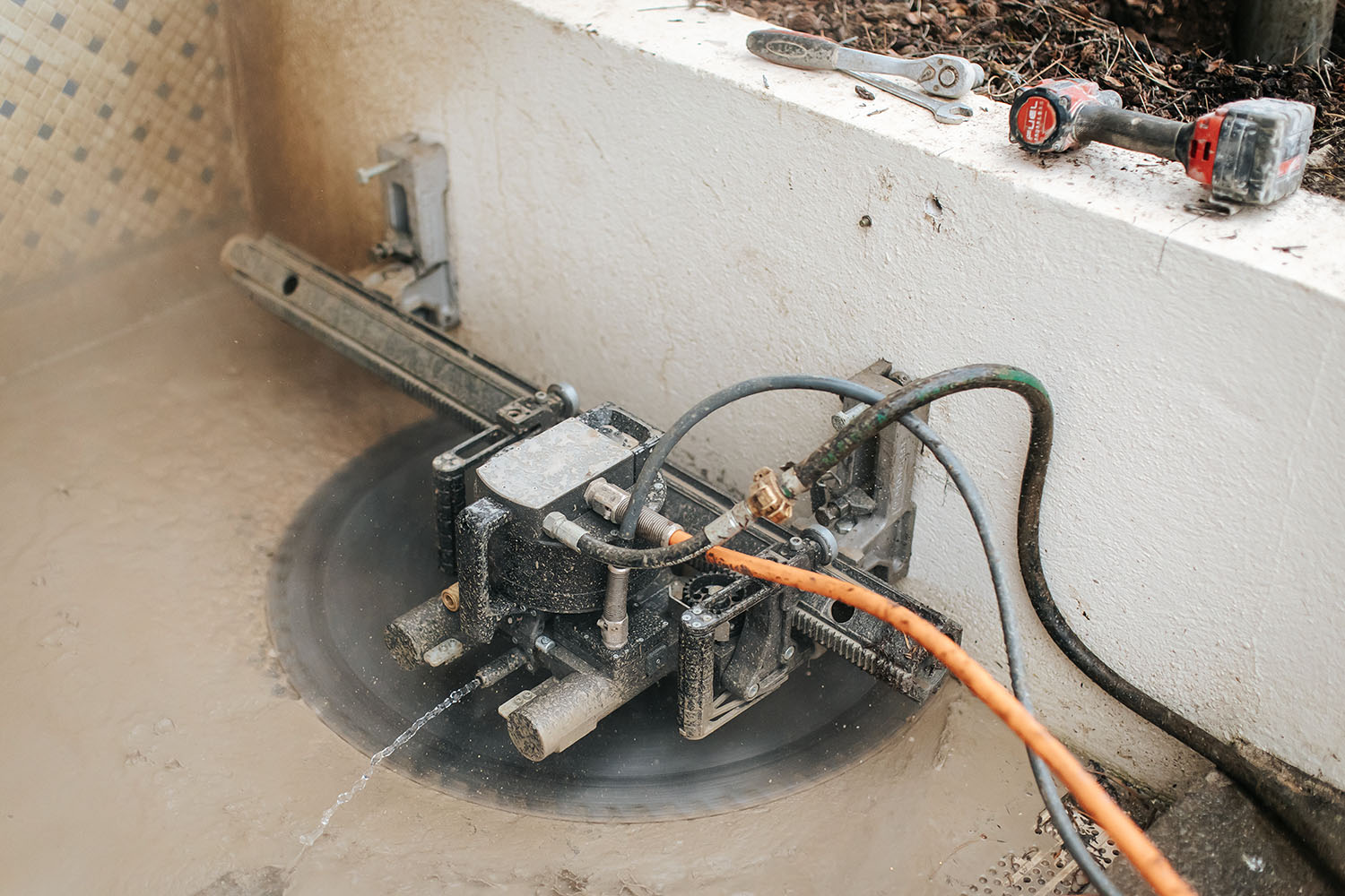 PHOTO D'UNE SCIE CIRCULAIRE ENTRAIN DE SCIER UN MURET EN BÉTON
